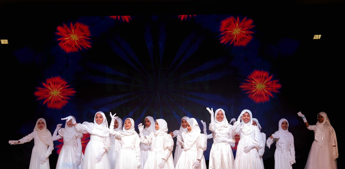 Girls in white performing on stage